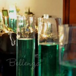 Green colored water centerpieces in tall glass cylinders.